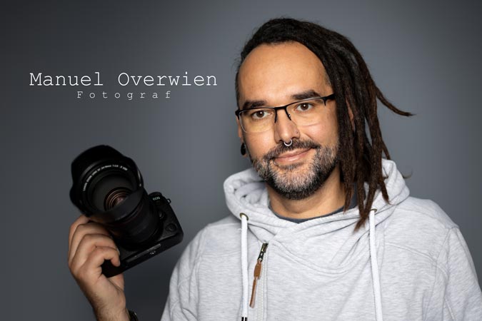 Ein Portrait des Hundefotografen Manuel Overwien mit seiner Kamera in der Hand